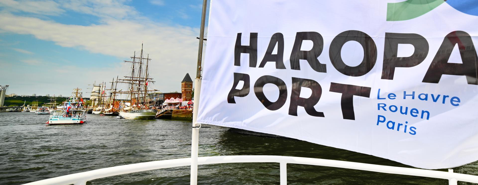 drapeau de HAROPA PORT sur une vedette ; en arrière plan certains bateaux de l'Armada à Rouen