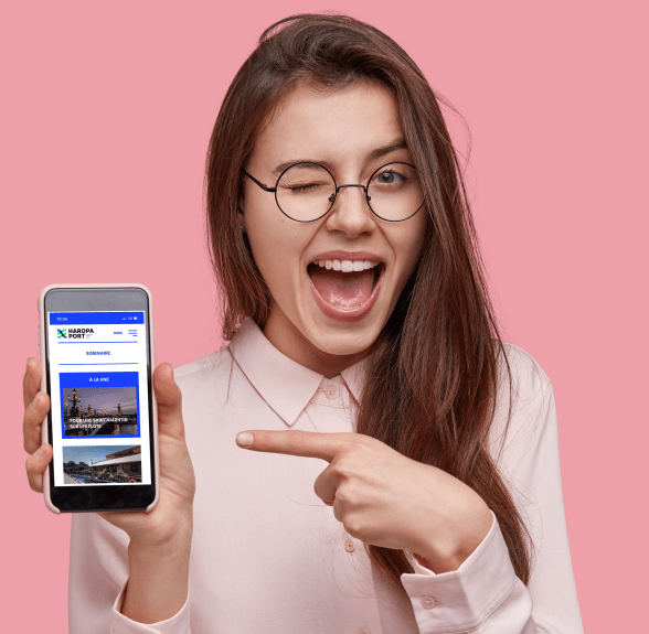 Jeune fille montrant un smartphone connecté sur l’application HAROPA PORT - Enlarge image, modal window